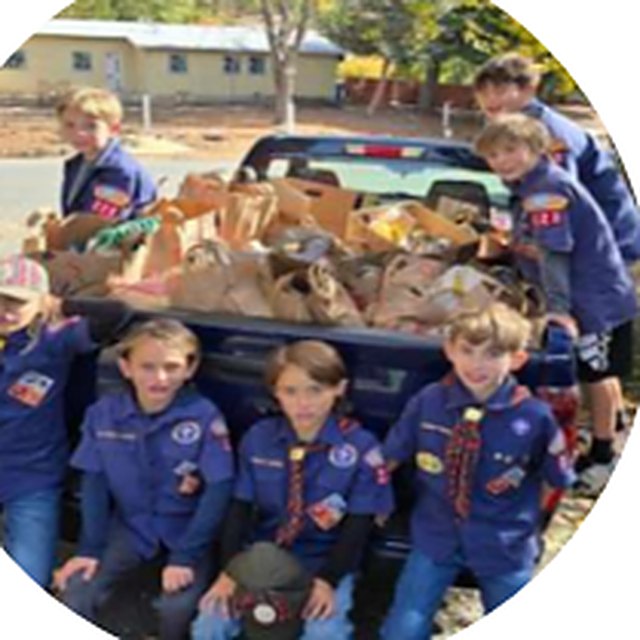 Cub Scouts with a truck bed full of donated food from the Scouting for Food drive